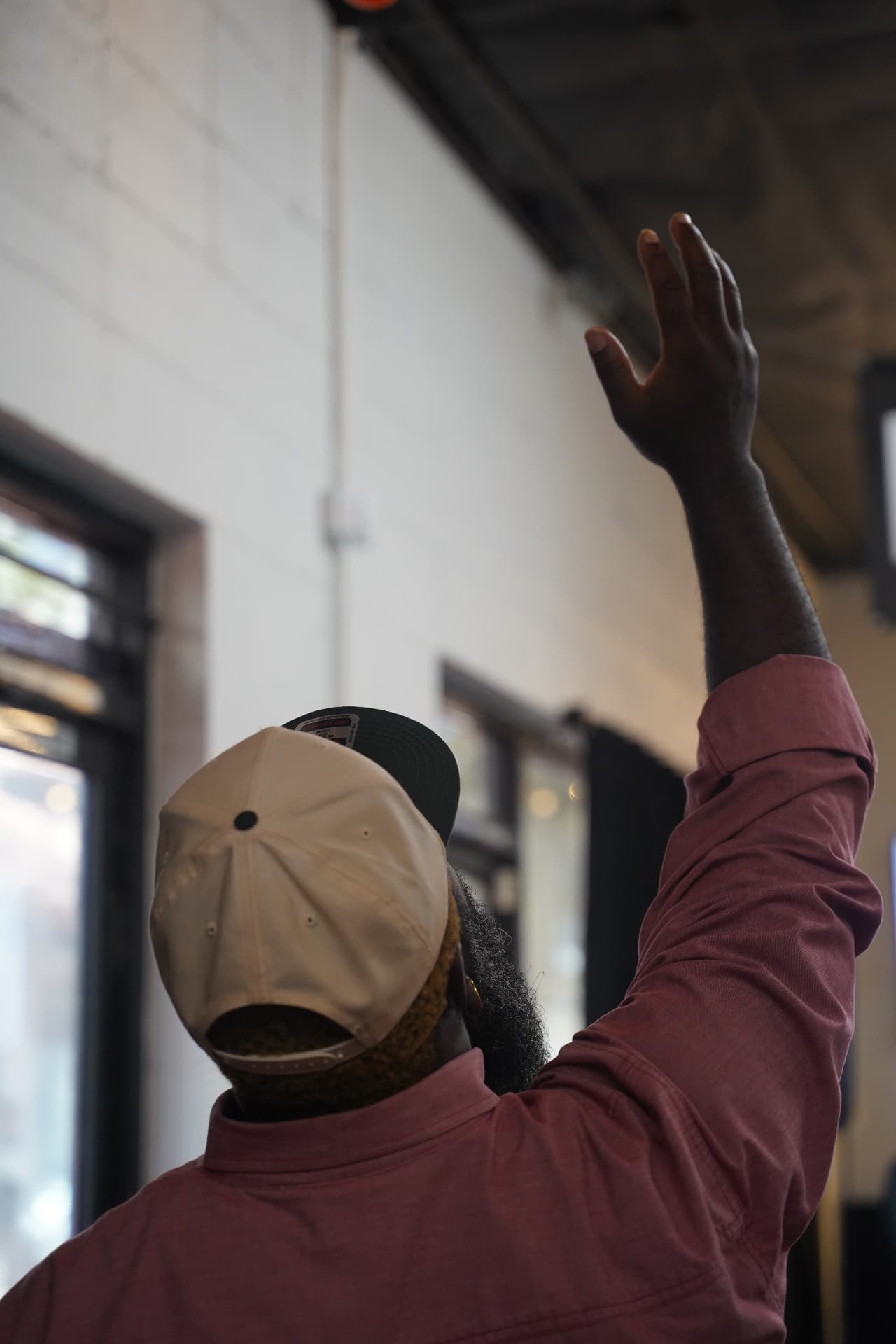 A C4 member raising his hand in worship during a Sunday gathering