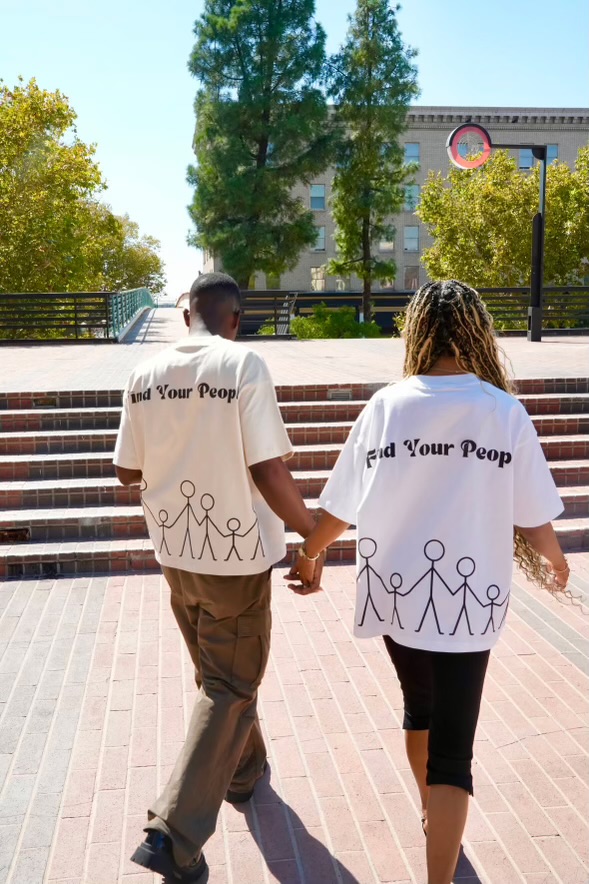 A couple walking downtown wearing Find Your People tees