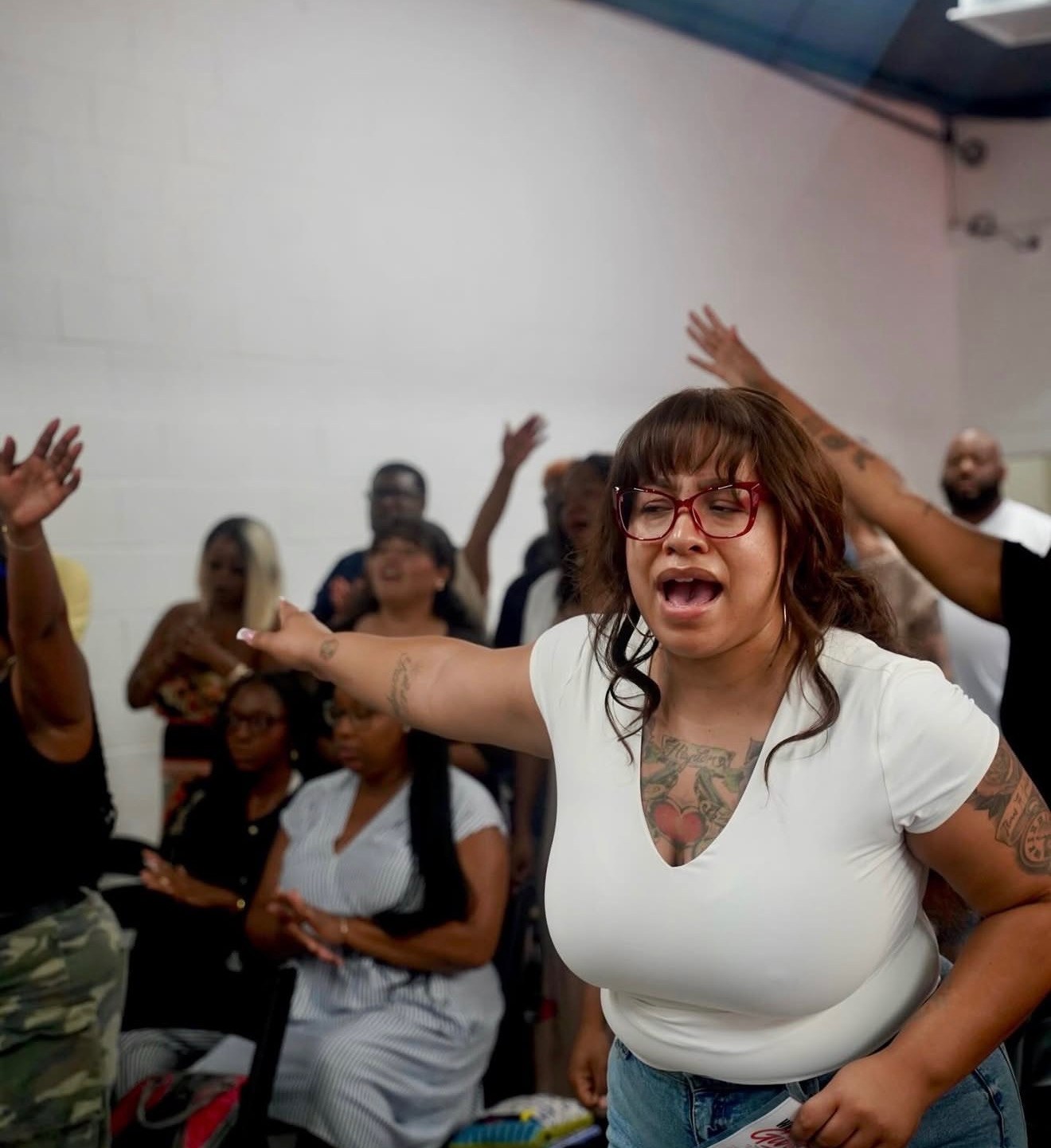 A woman worshipping with her arm outstretched during a Sunday Gathering